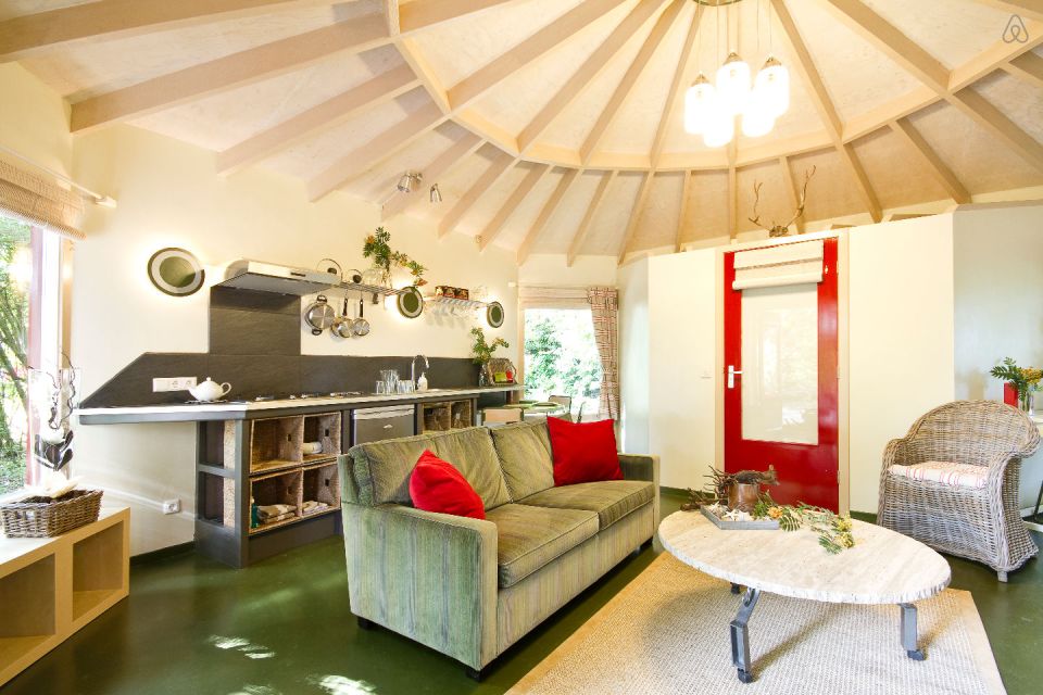"Forest House" is a yurt-like tiny cottage with rafters radiating out from the center and an open studio floor plan. | www.facebook.com/SmallHouseBliss